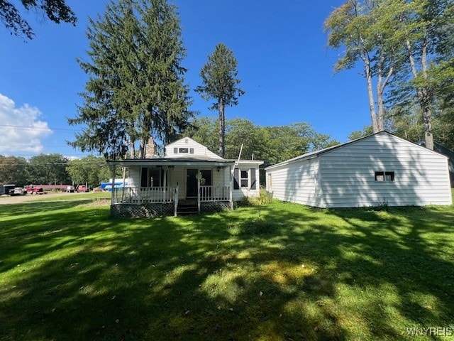 back of property with a porch and a yard