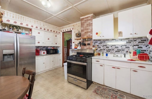 kitchen featuring tasteful backsplash, sink, stainless steel appliances, and white cabinets