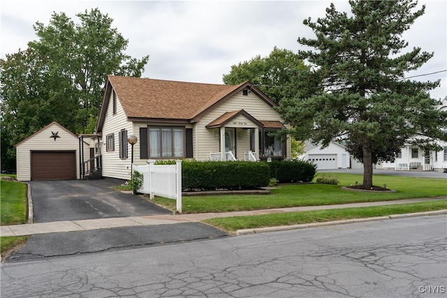 view of front of house featuring an outbuilding, a garage, and a front lawn