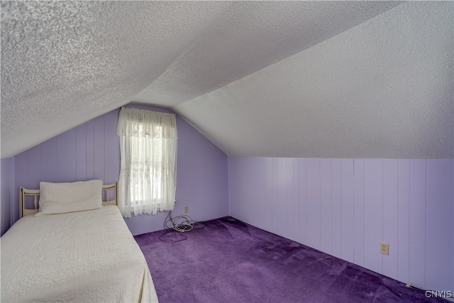 unfurnished bedroom featuring lofted ceiling, carpet, wooden walls, and a textured ceiling