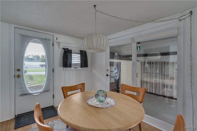 dining area featuring a textured ceiling and hardwood / wood-style flooring