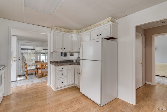 kitchen featuring light hardwood / wood-style flooring, white refrigerator, white cabinets, and a drop ceiling