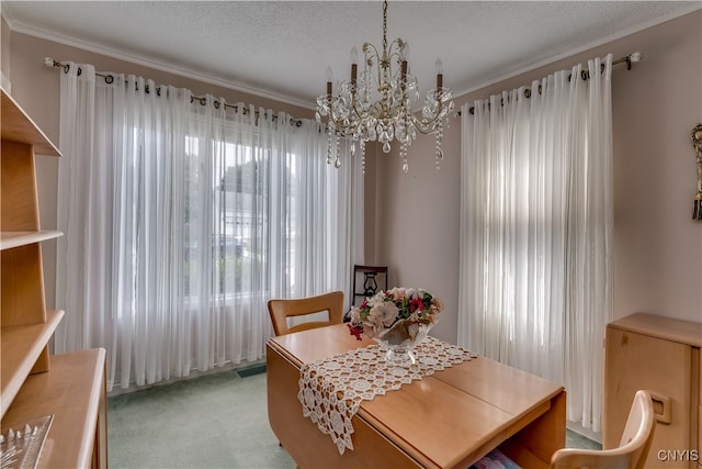 carpeted dining area featuring a textured ceiling, ornamental molding, and an inviting chandelier