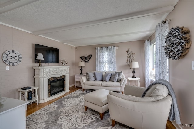 living room featuring a fireplace, a textured ceiling, hardwood / wood-style flooring, and beam ceiling