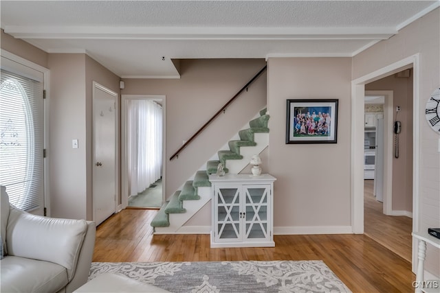 foyer entrance featuring a textured ceiling and light hardwood / wood-style flooring