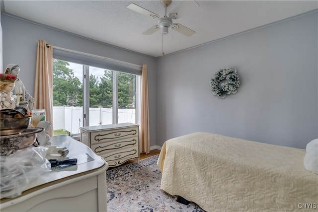 bedroom with ceiling fan, light hardwood / wood-style floors, and a textured ceiling