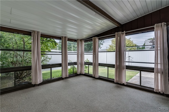 unfurnished sunroom with plenty of natural light and lofted ceiling with beams