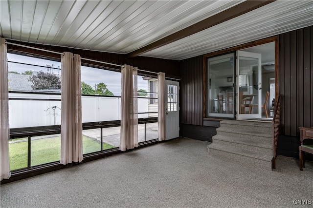 unfurnished sunroom featuring beam ceiling