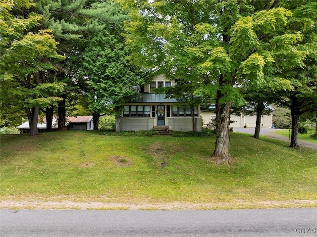 view of front facade featuring a front yard and a sunroom