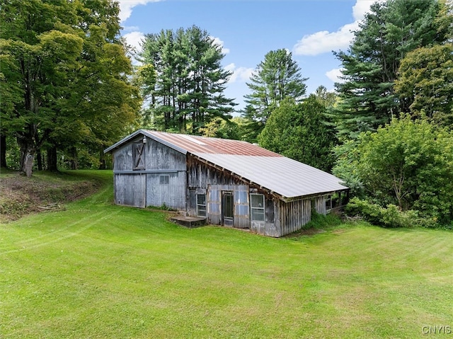 exterior space with an outdoor structure and a front lawn