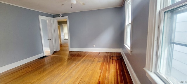 empty room featuring crown molding, hardwood / wood-style floors, and ceiling fan