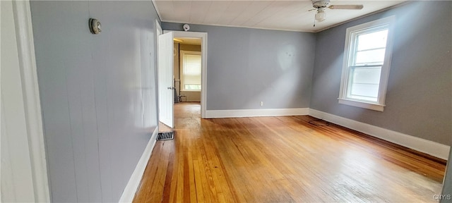 empty room with light hardwood / wood-style flooring, ceiling fan, crown molding, and a healthy amount of sunlight