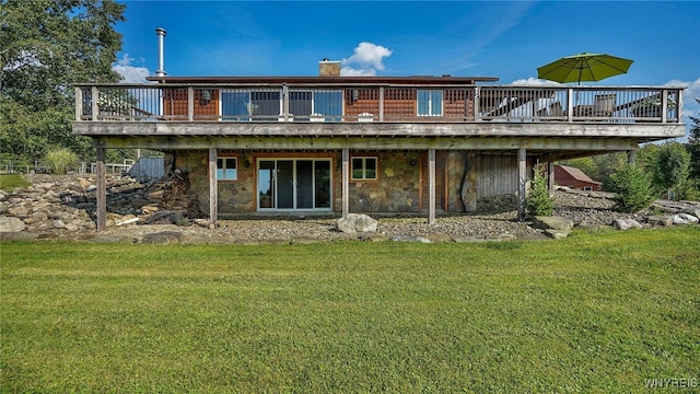 rear view of property featuring stone siding, a lawn, and a deck