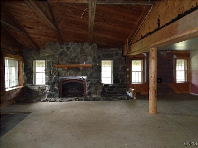 unfurnished living room with a healthy amount of sunlight, carpet flooring, and a stone fireplace