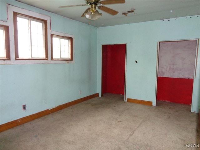 empty room with ceiling fan and light carpet