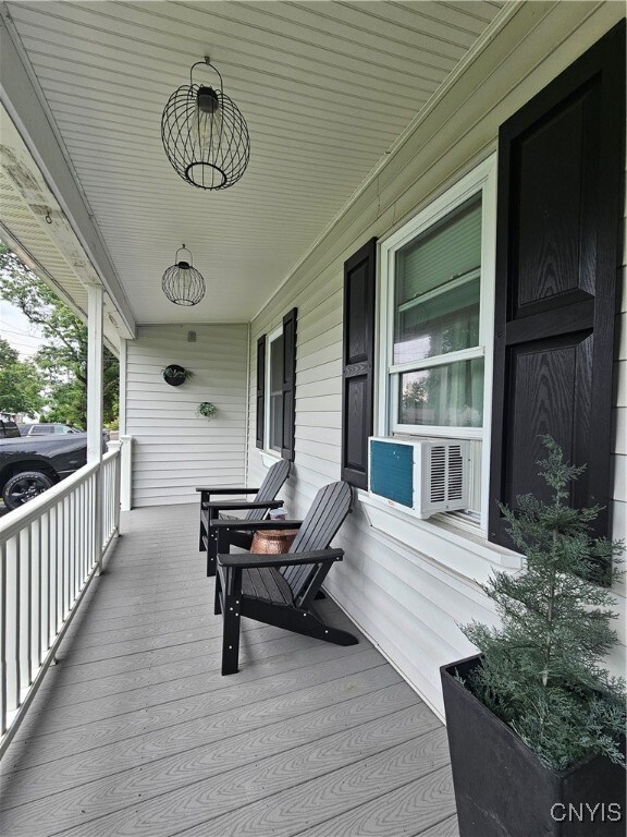 deck featuring cooling unit and a porch