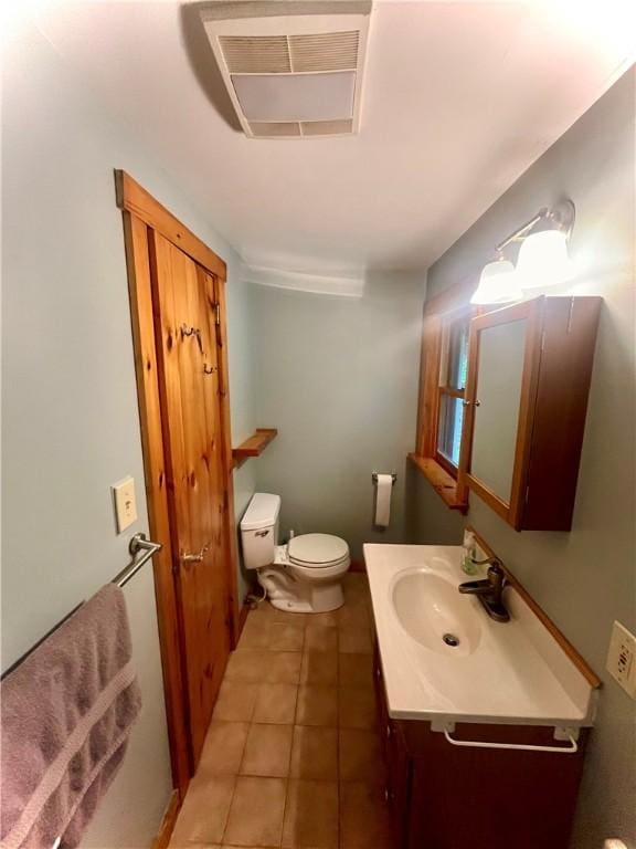 bathroom with tile patterned flooring, vanity, and toilet