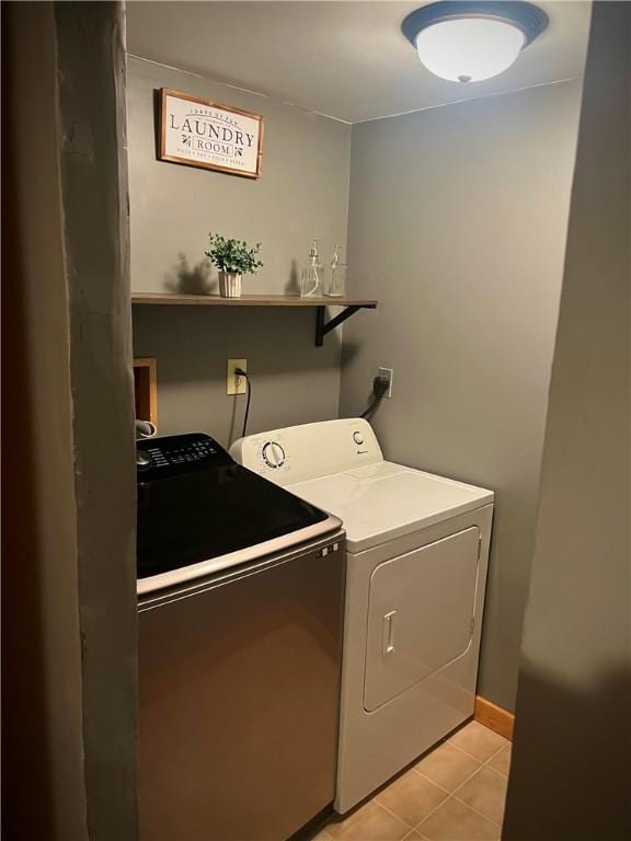 laundry area with light tile patterned floors and washing machine and dryer