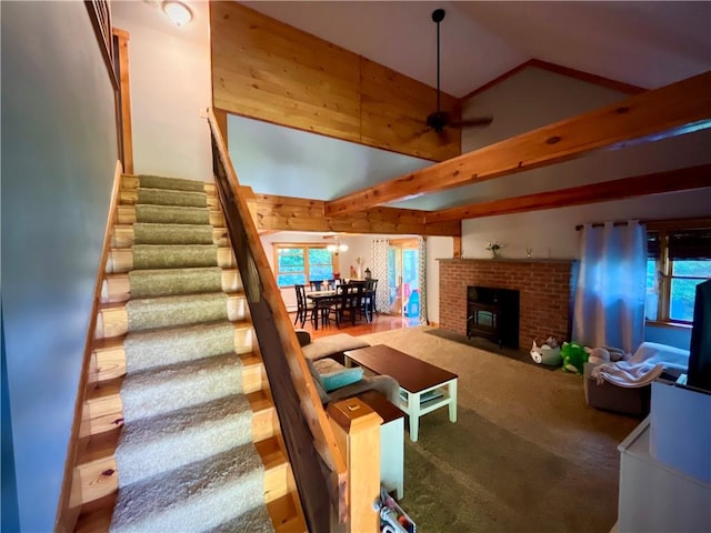 living room featuring wood-type flooring, high vaulted ceiling, a wood stove, and ceiling fan