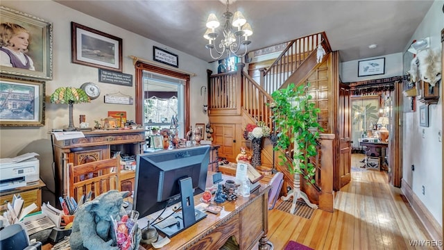 home office featuring light hardwood / wood-style floors and a notable chandelier