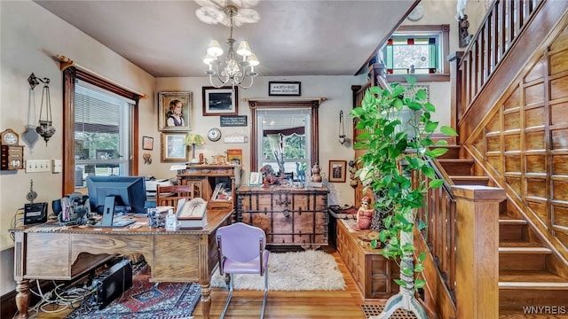 home office featuring wood-type flooring and a notable chandelier