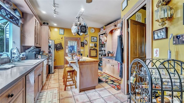 kitchen with a center island, butcher block countertops, sink, appliances with stainless steel finishes, and a kitchen breakfast bar