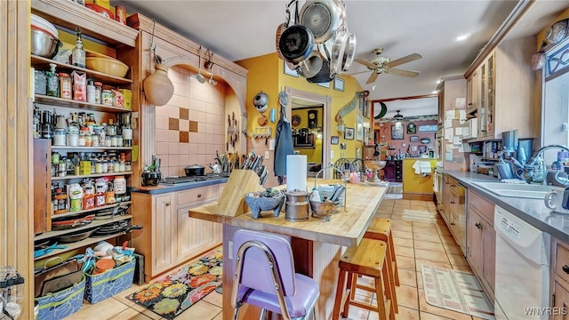 kitchen featuring light brown cabinets, wooden counters, sink, and white dishwasher