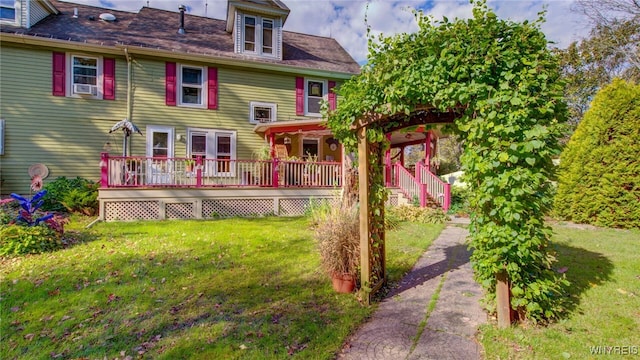 back of house featuring a wooden deck and a lawn