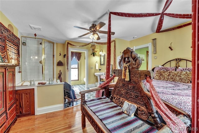 bedroom featuring ceiling fan, connected bathroom, and light wood-type flooring