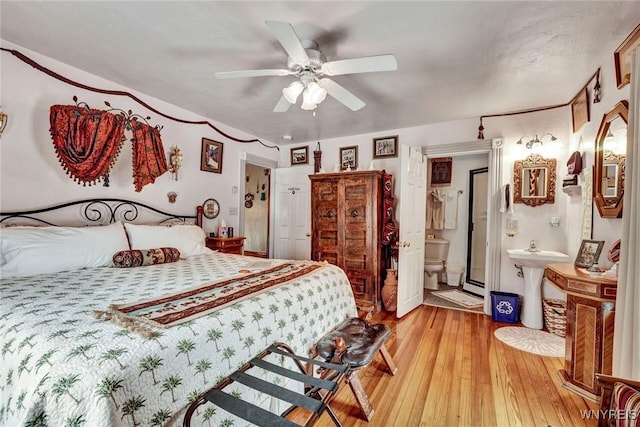 bedroom with ensuite bath, ceiling fan, sink, and light hardwood / wood-style floors