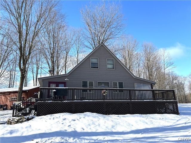 snow covered house featuring a deck