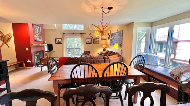 dining area with light carpet and a notable chandelier