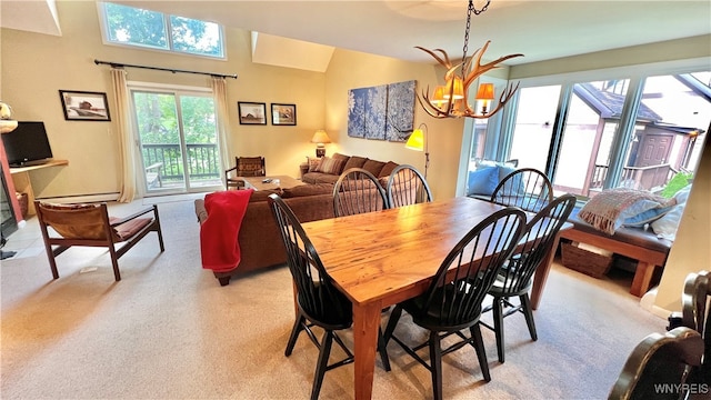 dining area featuring a notable chandelier, light colored carpet, and a baseboard radiator