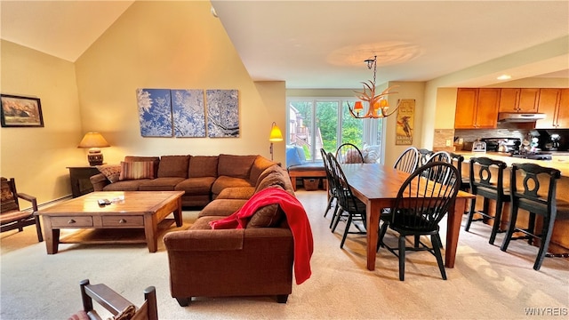 carpeted living room with an inviting chandelier and lofted ceiling