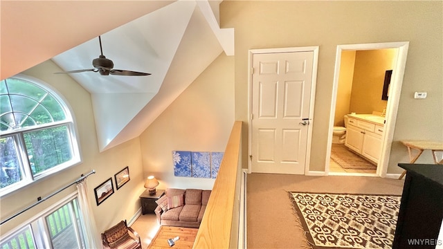 interior space featuring ensuite bathroom, vaulted ceiling, and ceiling fan