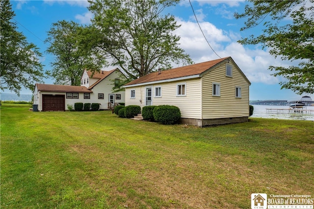 rear view of house featuring a yard and a water view