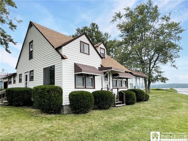 view of front of home featuring a water view and a front lawn