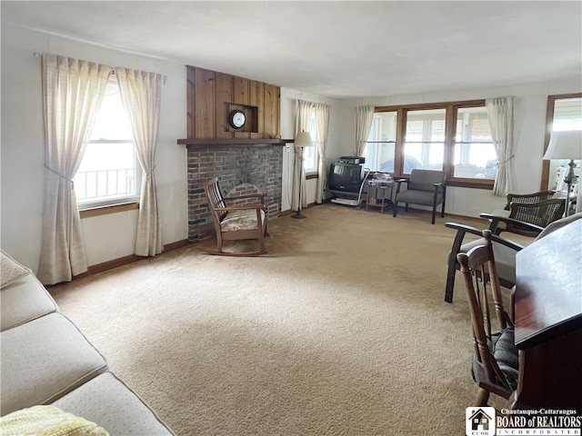 living room featuring light carpet, a fireplace, and a wealth of natural light