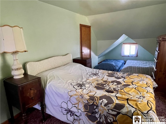 carpeted bedroom with lofted ceiling