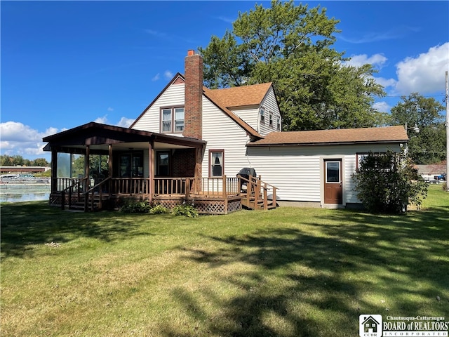 back of property featuring a yard and a wooden deck