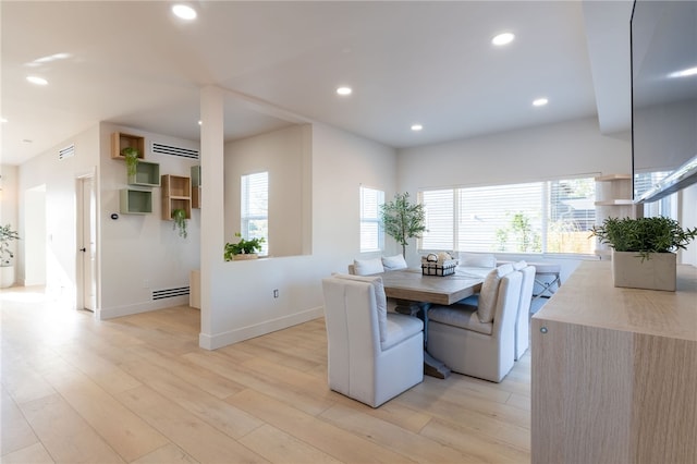 dining room with light wood-type flooring and a healthy amount of sunlight