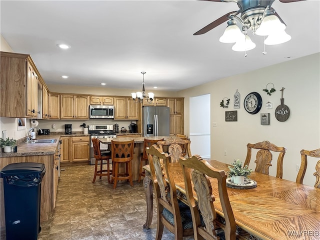 dining room featuring ceiling fan with notable chandelier and sink