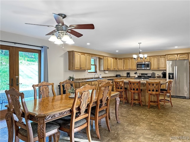 dining room featuring ceiling fan with notable chandelier, french doors, plenty of natural light, and sink