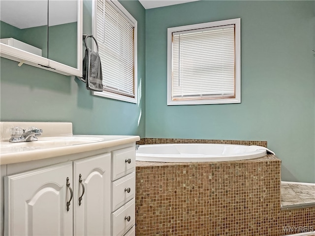 bathroom with tiled bath and vanity