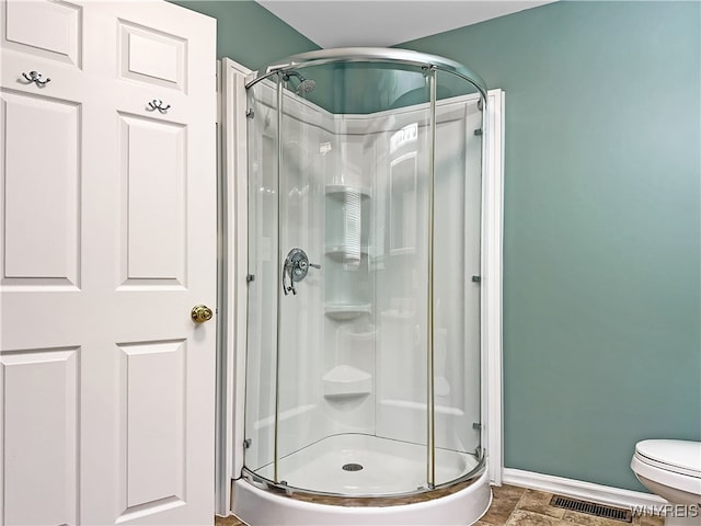 bathroom with toilet and a shower with shower door