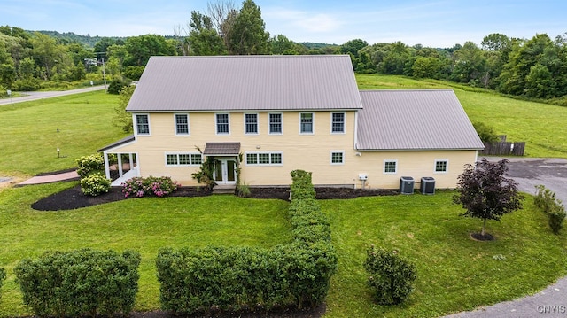 view of front of house with a front lawn and central AC unit