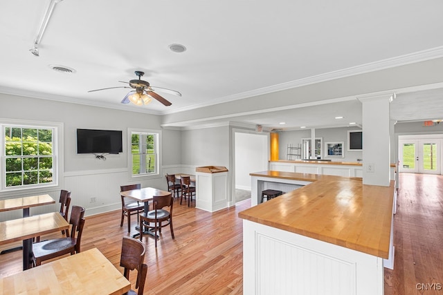 kitchen with crown molding, butcher block counters, ceiling fan, and light hardwood / wood-style floors