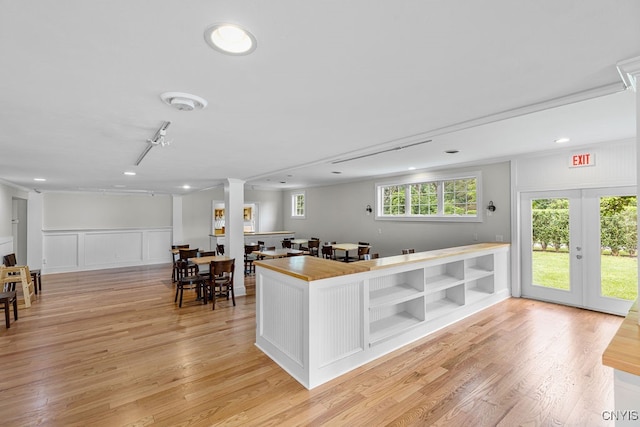 kitchen featuring ornamental molding, french doors, ornate columns, and light hardwood / wood-style floors