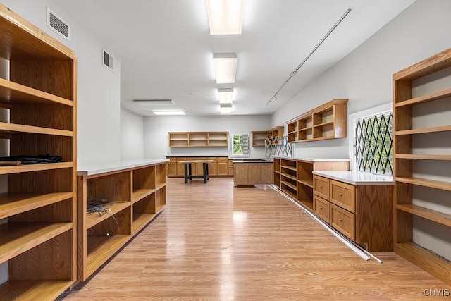 interior space with built in desk and light hardwood / wood-style floors