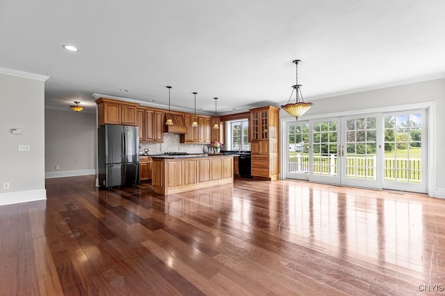 kitchen featuring crown molding, hanging light fixtures, dark hardwood / wood-style floors, and stainless steel fridge